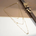 Collier multi-rangs doré avec maillons marins et zircons sur fond beige